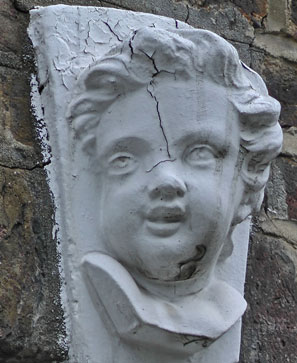 A white cherub's face above one of the house doorways.